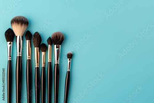 Set of professional makeup brushes on blue background