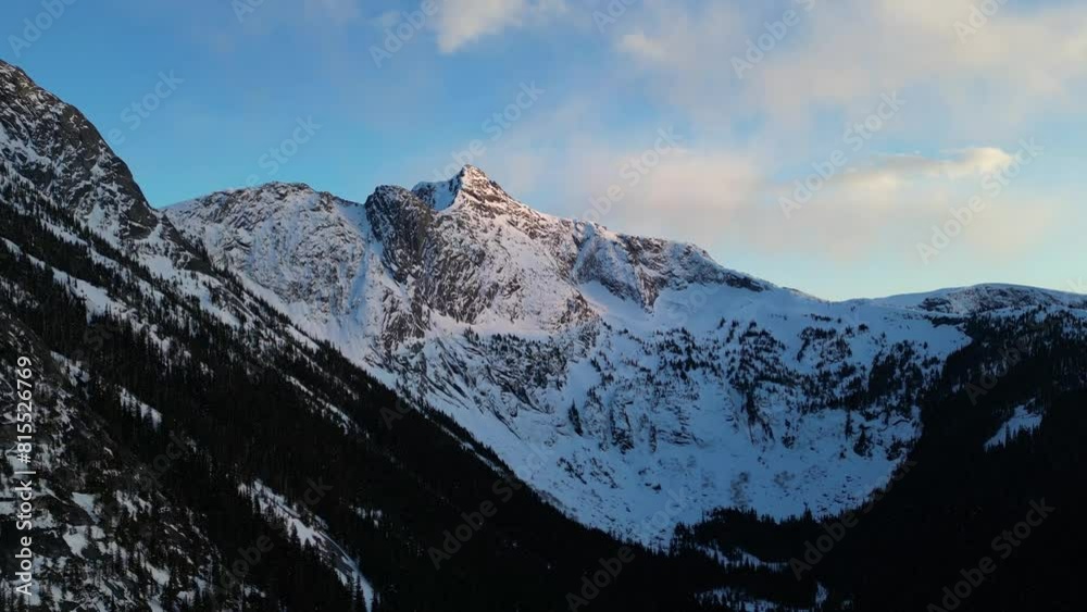 Rocky Mountain Peaks with Snow and Trees. Blue Sky and Clouds. Sunset, Spring Season. British Columbia, Canada. Rocky Mountain Peaks with Snow and Trees. Blue Sky and Clouds. Sunset, Spring Season. British Columbia, Canada.