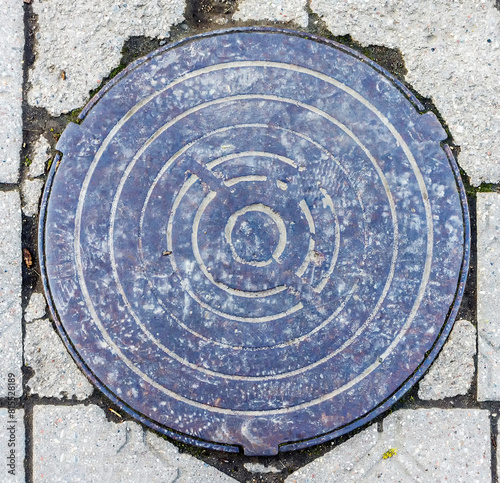 view of the old manhole cover of the city between the blocks