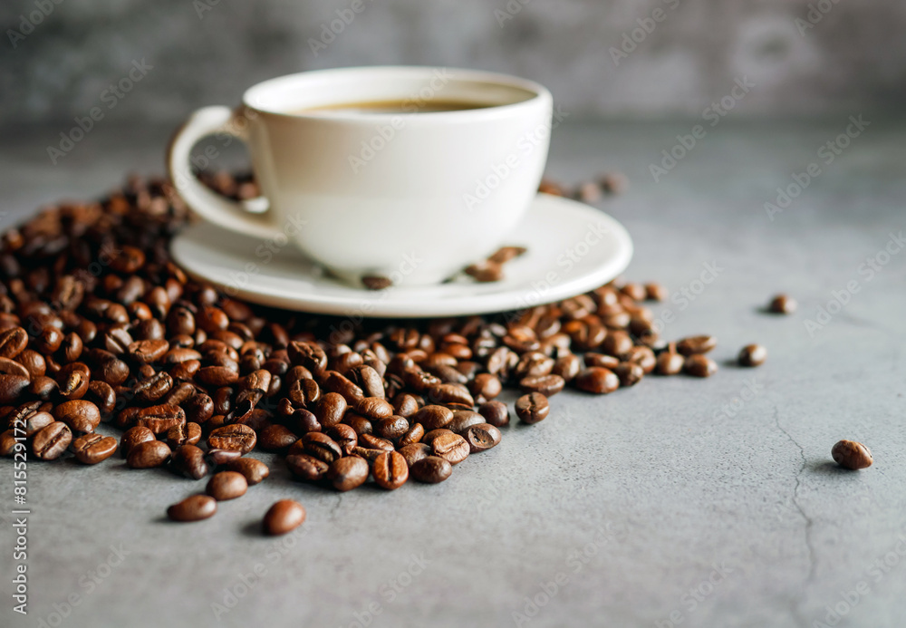 Fototapeta premium Close up of backdrop dark brown coffee beans and coffee cup background.