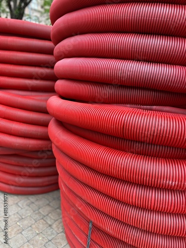 Texture of red plastic protective tubes for power lines. Urban engineering concept. Photo of a mobile phone, not AI
