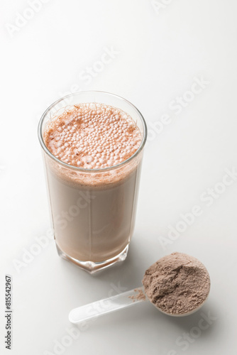Protein drink cocktail in a glass and whey protein powder in a measuring scoop
