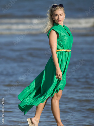 Young woman on the beach in beautiful dress photo