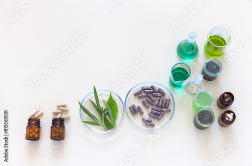 Development of new dietary supplements and nutrition additions with herbal extract. Top view of laboratory table with chemical glassware and dietary supplements in Petri dish. Flat lay, copy space