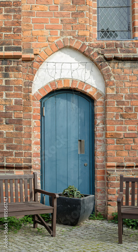 Rückwärtiges Portal an der Hofseite der spätgotischen "Siechenhauskapelle" in Neuruppin mit Sitzbänken und Blumenkübel