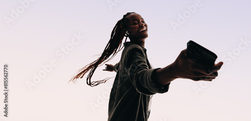 Cheerful young woman dancing and listening to music with confidence