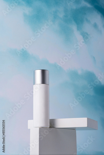 Cosmetic pink bottle, bottle, lotion or serum with stylish props on sky background. 