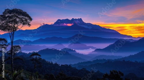 A beautiful landscape image of Mount Kinabalu  the highest mountain in Borneo. The sky is a deep blue and the sun is rising over the horizon.