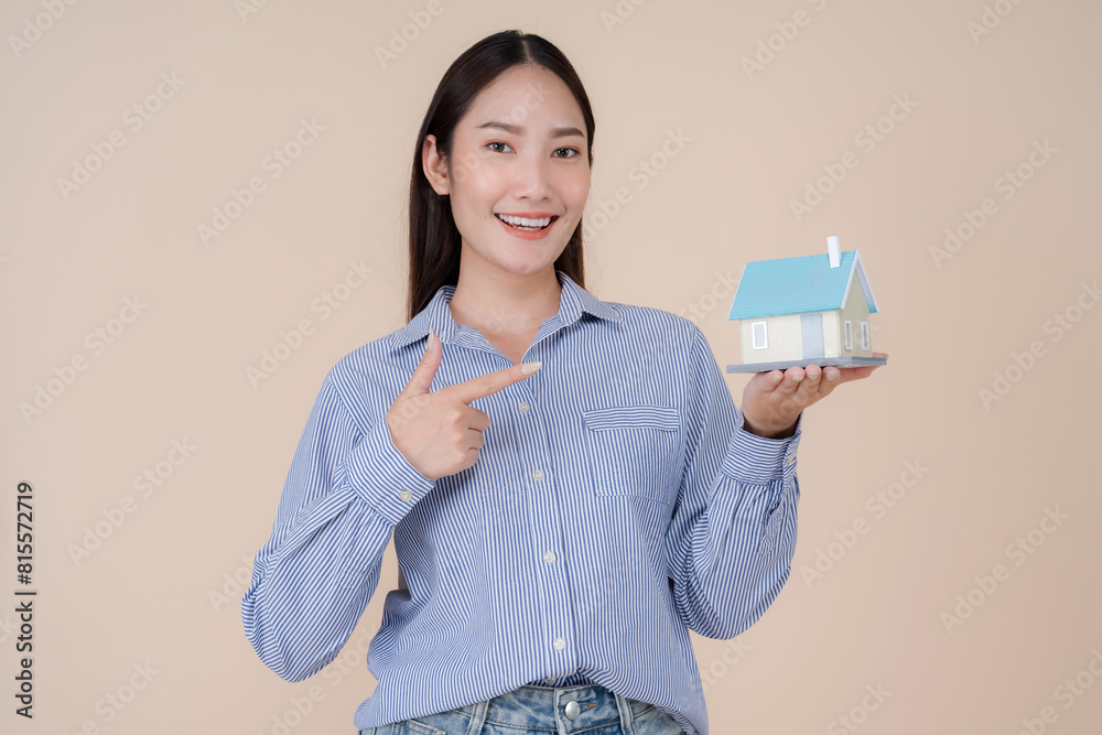 Smiling young woman holding miniature house model Smiling young woman holding miniature house model