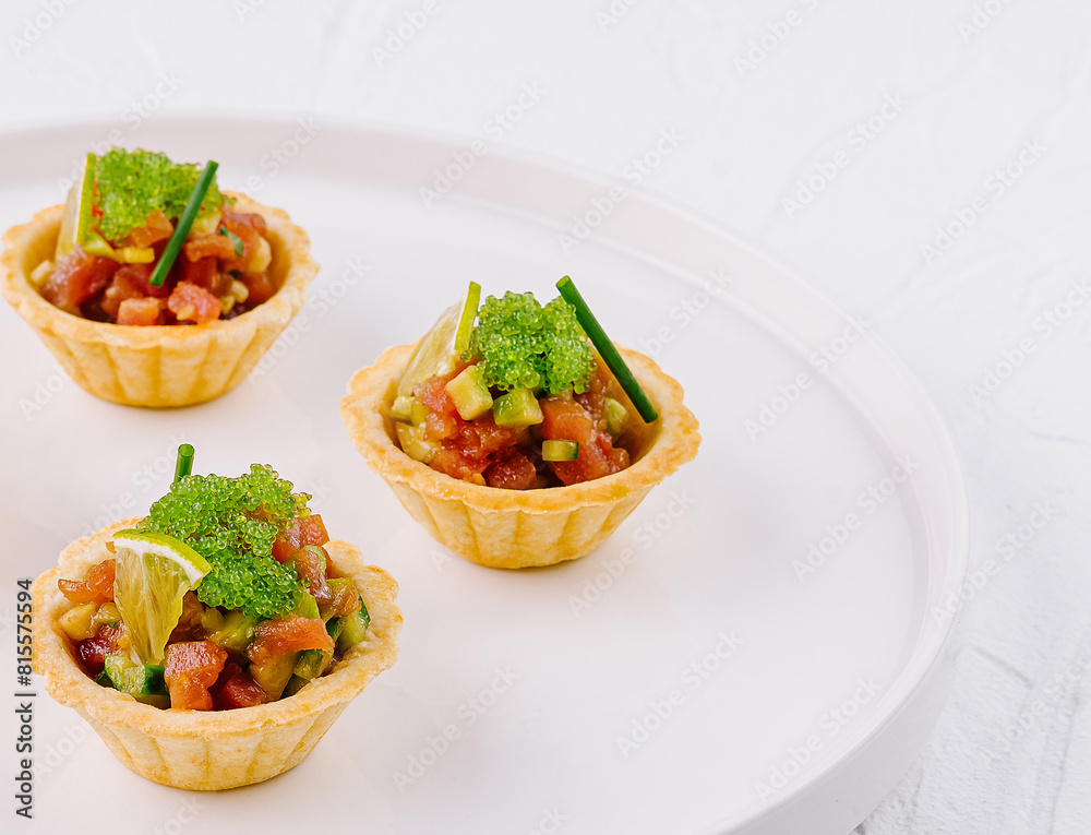 Fresh veggie tartlets on white plate