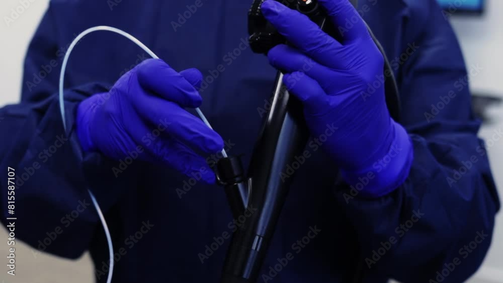 doctor with blue latex gloves preparing endoscopy equipment for procedure 60fps