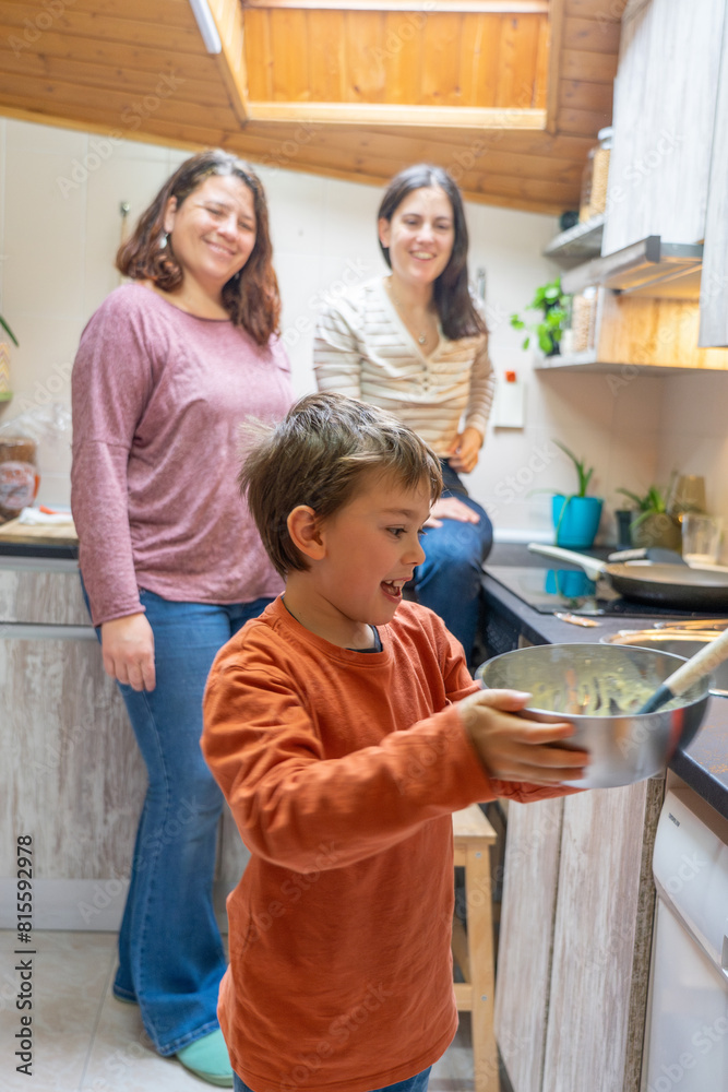 LGBT family of two lesbian mothers and their son cooking together in the kitchen at home LGBT family of two lesbian mothers and their son cooking together in the kitchen at home