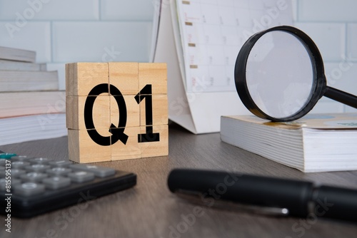Close up image of wooden cubes with alphabet Q1 on office desk. First quarter concept.