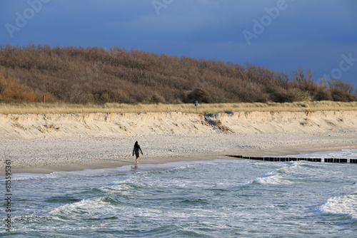eine junge Frau geht allein am Strand spazieren