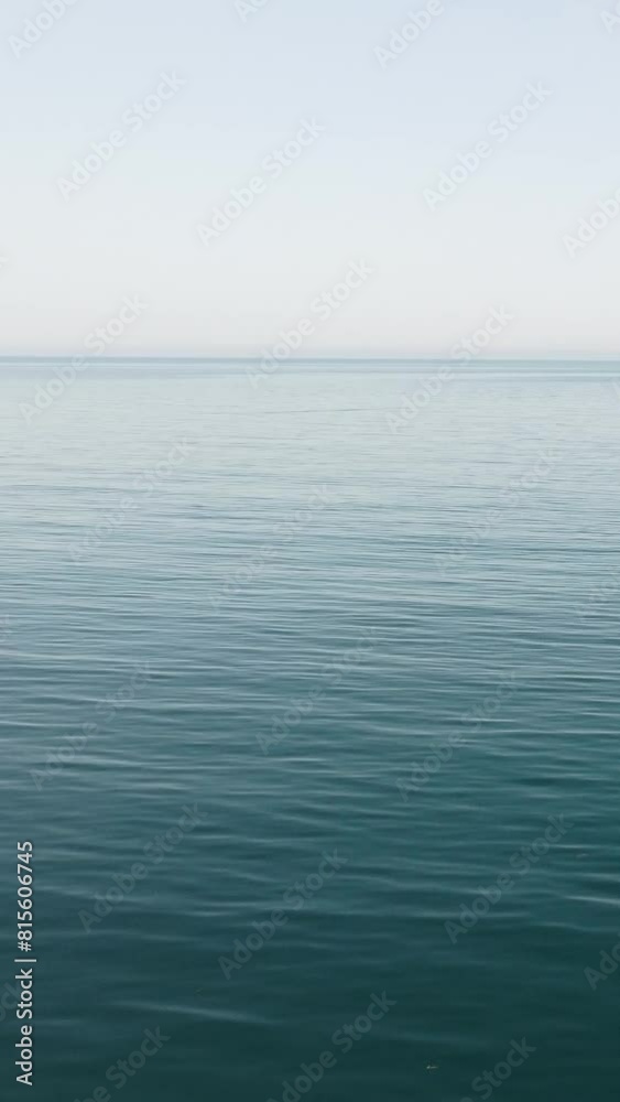 Vertical aerial view over calm azure sea water surface. Sun glare. Abstract nautical summer ocean nature. Holiday, vacation and travel concept. Nobody. Weather and climate change Vertical aerial view over calm azure sea water surface. Sun glare. Abstract nautical summer ocean nature. Holiday, vacation and travel concept. Nobody. Weather and climate change