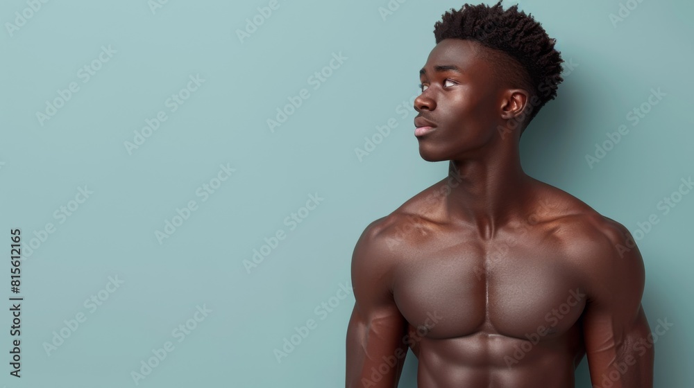 Fototapeta premium A portrait of a young, muscular man stretching, showcasing strength and fitness against a teal background.
