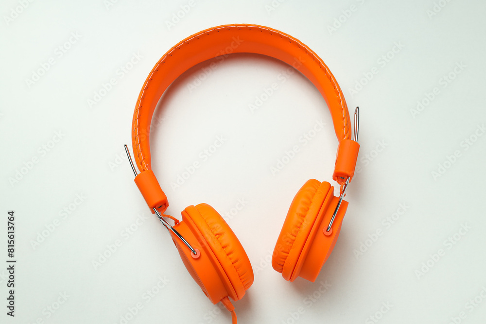 Fototapeta premium On-top, large, bright orange headphones, on a light background.