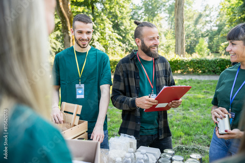 Food bank - Group of volunteers during a solidarity event - Manager checks that everything has been set up while the workers prepare the boxes for the donation