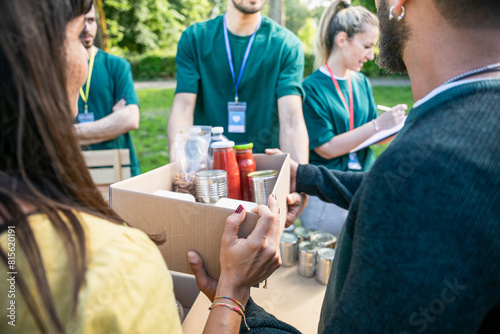 Food bank - Group of volunteers in uniform prepare boxes of basic necessities to donate them to people in need photo