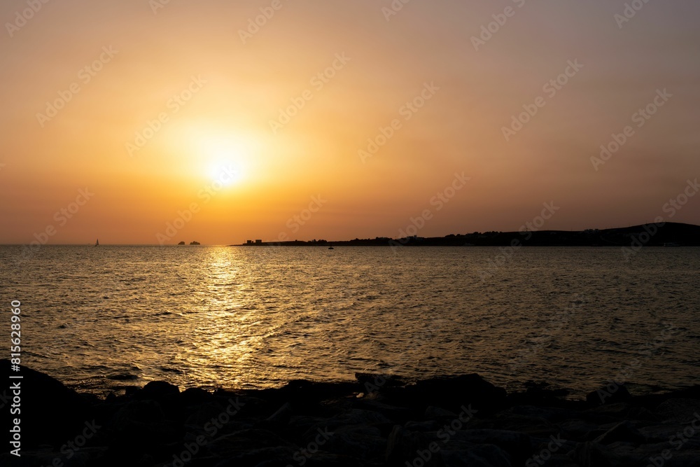 Beautiful landscape of a lake with a glowing orange sunset in the background Beautiful landscape of a lake with a glowing orange sunset in the background