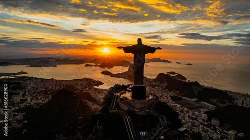 Fototapeta Naklejka Na Ścianę i Meble -  Aerial view of a golden sunset illuminating the statue of Jesus Christ in Rio de Janeiro, Brazil.