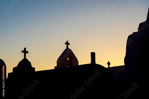 Stunning view of the Panagia Paraportiani church with sunbeams radiating out of the sky at sunset photo