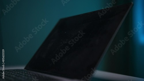 Cropped shot of unrecognizable woman cleaning dirty dusty laptop screen with spray and microfiber cloth at home, closeup. Concept of domestic work, housekeeping and household. Shooting in slow motion. photo