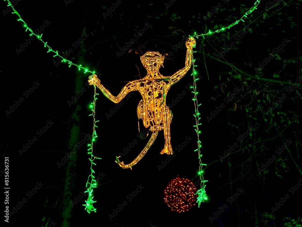 Fototapeta premium a christmas tree with green lights is shown as it sits next to a red ball