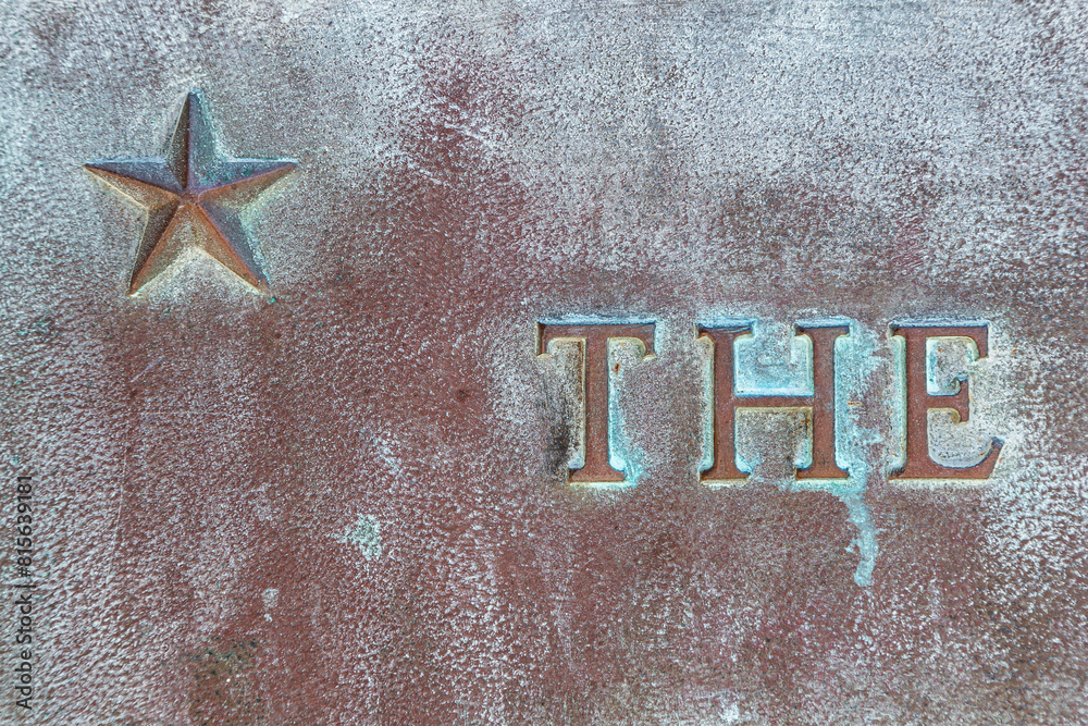 Patena Lettering Star with patina. Star on a bronze monument. Inscription THE on a ...