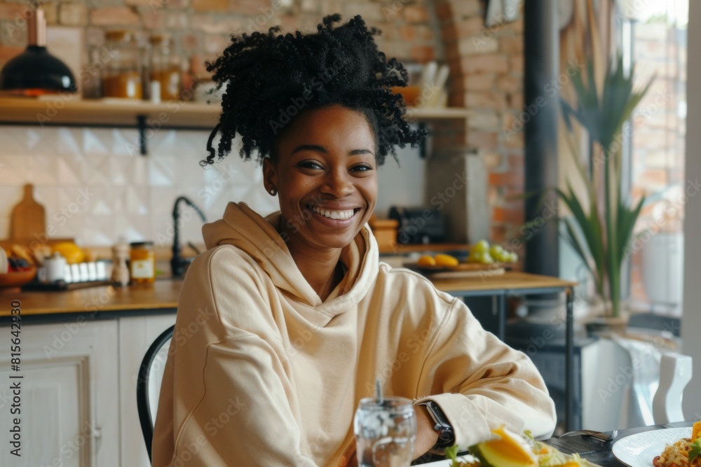 Black woman seated at a sunlit breakfast table. She embodies a serene start to the day, smiling warmly, Black woman seated at a sunlit breakfast table. She embodies a serene start to the day, smiling warmly,