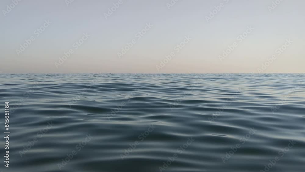 Relaxing view of sea surface ripples and waves at sunset. View divided by the horizon between water and sky. Relaxing view of sea surface ripples and waves at sunset. View divided by the horizon between water and sky.