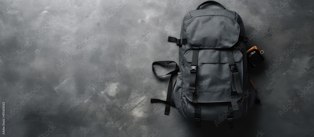 Fototapeta premium Professional photography equipment in backpack on grey stone table top view Space for text. copy space available