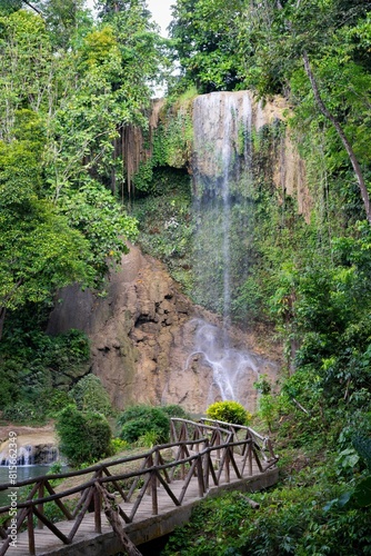 Fototapeta Naklejka Na Ścianę i Meble -  an image of a person on a bridge that is by some waterfall