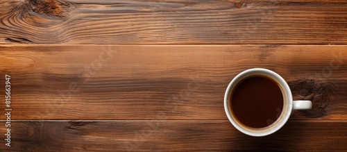 Top view of a cup of coffee on wood background with copy space and texture