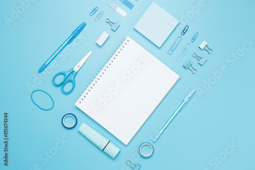 Creative flat lay mockup design of workspace. Top view composition with white notebook, to do list and stationery on blue background