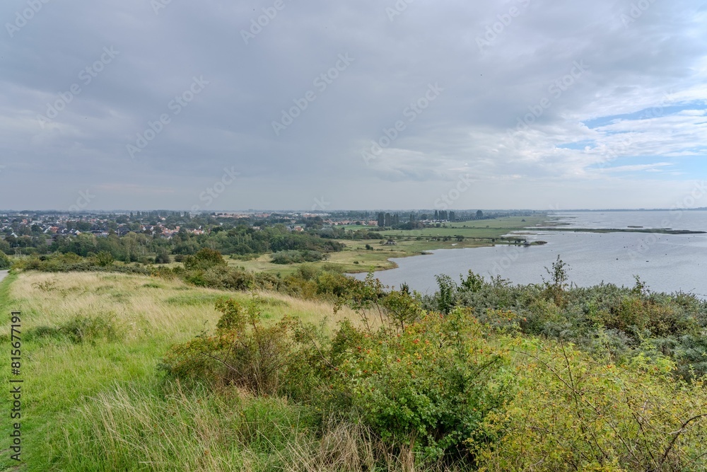 an expansive lake in the distance under a grey sky with some clouds an expansive lake in the distance under a grey sky with some clouds