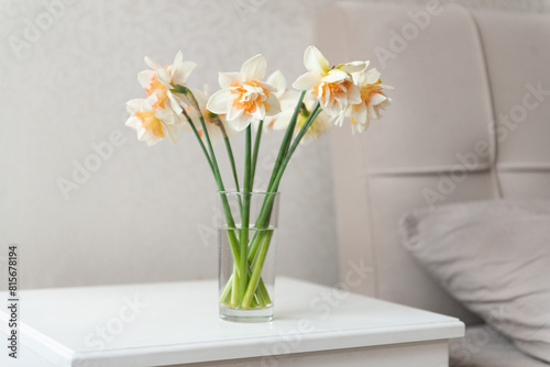 narcissus flower bouquet in small glass vase at home