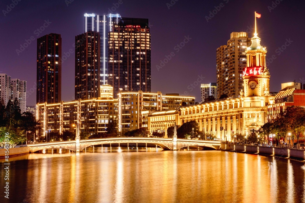 Fototapeta premium cityscape of a bustling metropolitan area illuminated by bright lights in the night sky, Shanghai