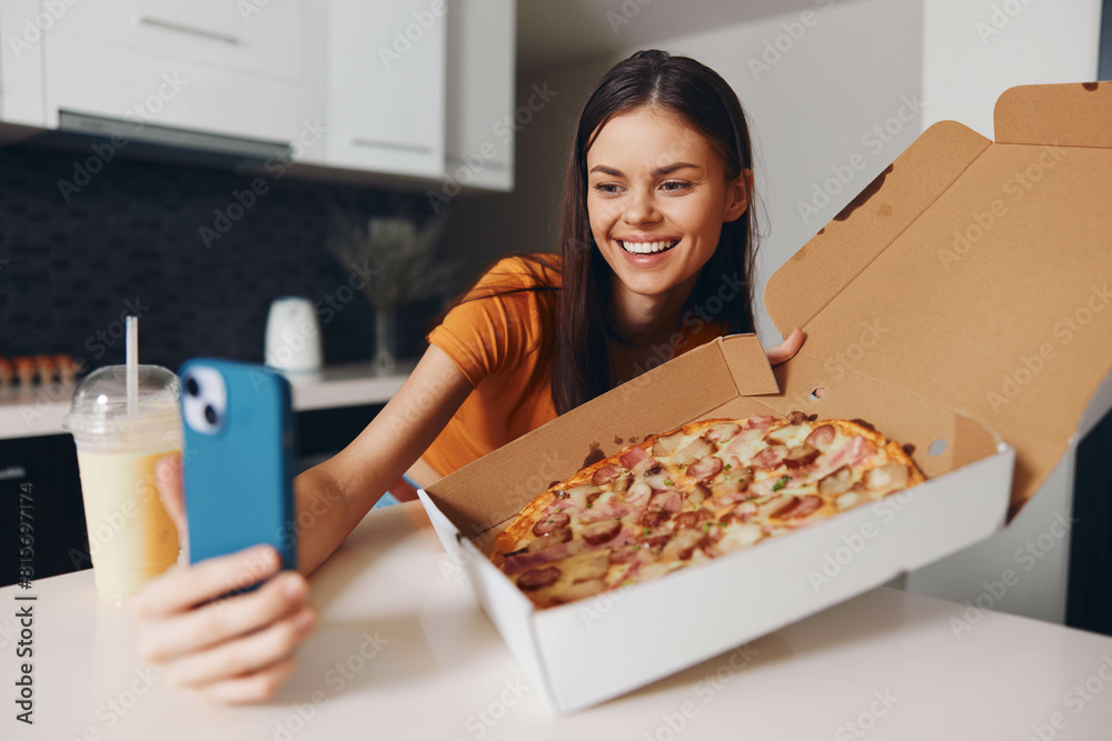 Woman capturing a delicious moment taking a photo of a pizza with her phone at a table Woman capturing a delicious moment taking a photo of a pizza with her phone at a table