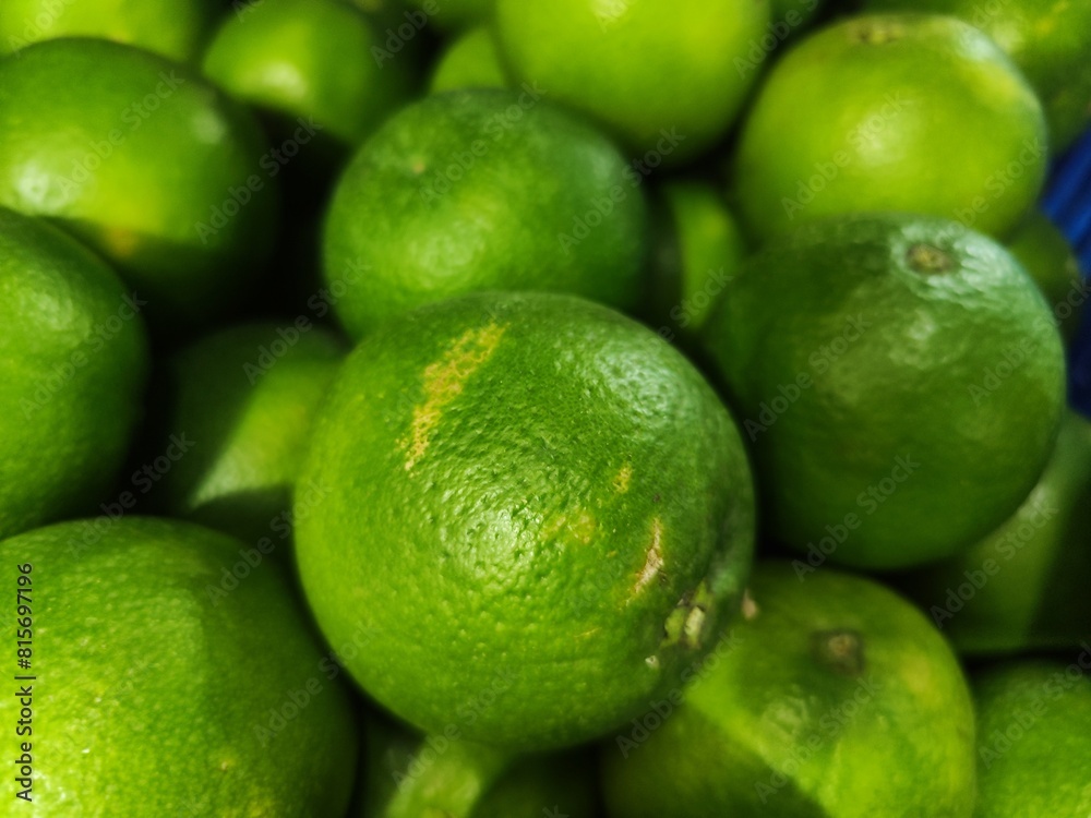 Close-up of a cluster of fresh limey lemons on a display Close-up of a cluster of fresh limey lemons on a display