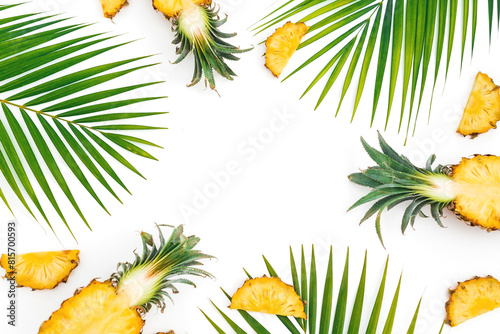 Tropical frame with pineapple and palm tree leaves on white background. Flat lay, top view. © artifirsov