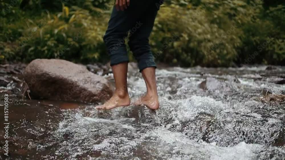 A person walks through a river with water flowing through the rocks, Seamless looping time-lapse virtual 4k video animation background A person walks through a river with water flowing through the rocks, Seamless looping time-lapse virtual 4k video animation background