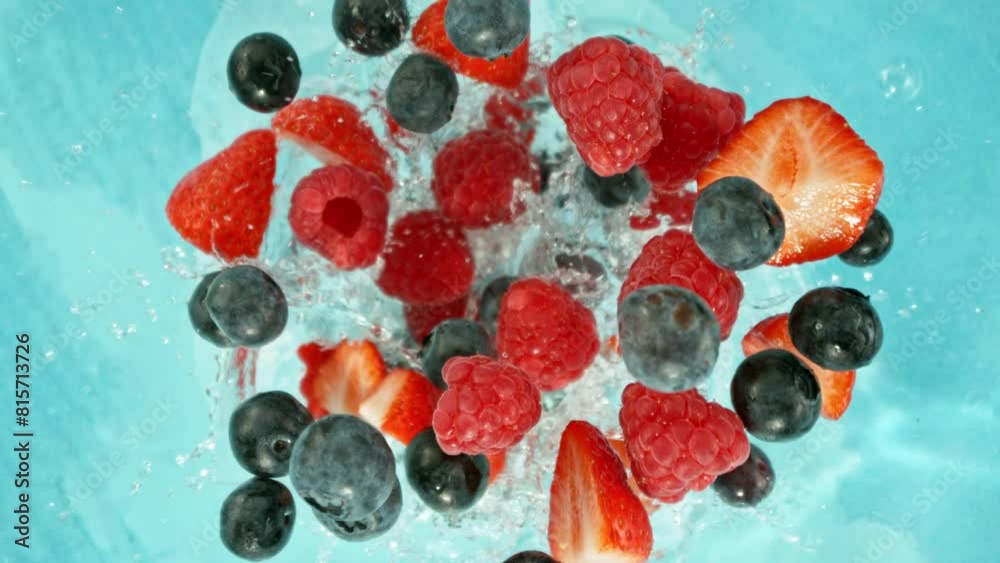 Super Slow Motion of Falling Berries into Water, Blue Background. Filmed on High Speed Cinema Camera, 1000 fps. Camera Tracking the Target. Super Slow Motion of Falling Berries into Water, Blue Background. Filmed on High Speed Cinema Camera, 1000 fps. Camera Tracking the Target.