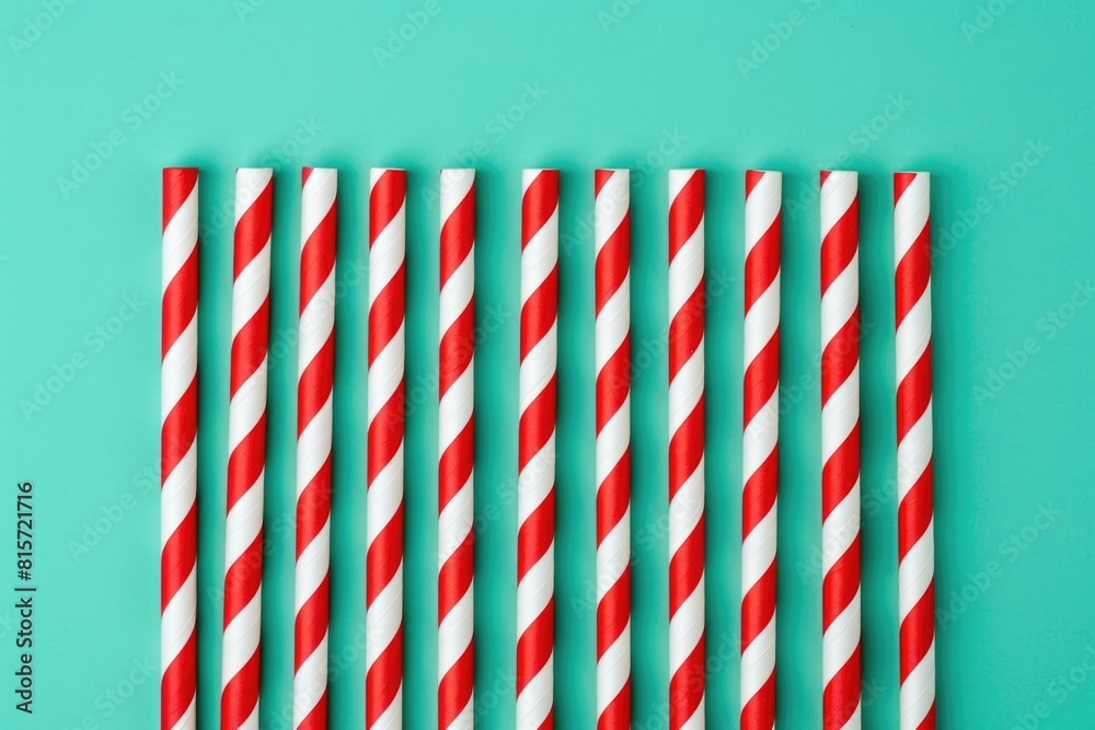 Red and White Striped Paper Straws on a Green Background Red and White Striped Paper Straws on a Green Background