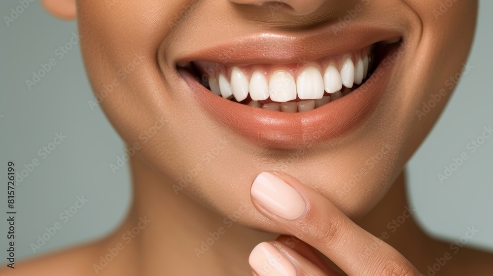The image shows a close-up of the lower half of a woman's face, highlighting a bright and cheerful smile. She has healthy, white teeth, and her skin is smooth with a neutral tone. The image shows a close-up of the lower half of a woman's face, highlighting a bright and cheerful smile. She has healthy, white teeth, and her skin is smooth with a neutral tone.