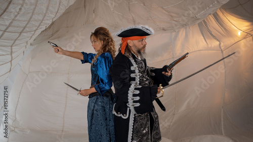 A lady with a dagger and a pirate in an old doublet with a saber photo
