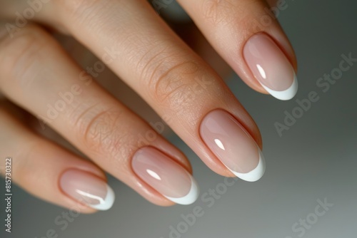 Close-up of a woman's hand with an elegant neutral manicure. Beautiful light pink gel nail polish on rectangular nails