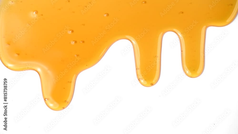 Honey dripping, pouring, flowing over white background. Close-up. Healthy organic liquid sweet sticky honey dipping, isolated on white, closeup. Slow motion 