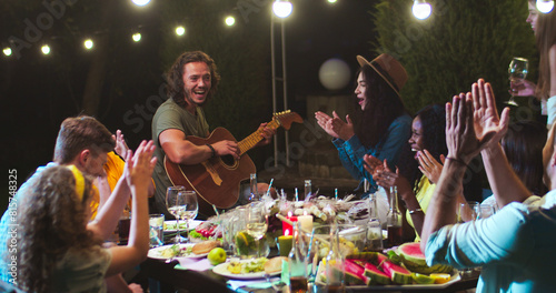 Photography Joyful mixed-race young people having fun at party in garden at summer evening