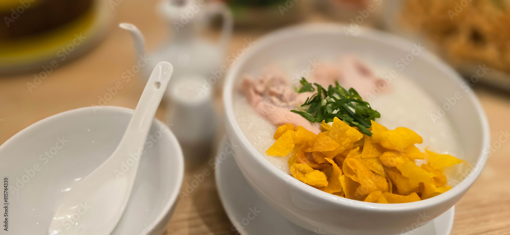 rice porridge with shredded chicken called bubur ayam served with crackers and sliced spring onion and others condiments rice porridge with shredded chicken called bubur ayam served with crackers and sliced spring onion and others condiments